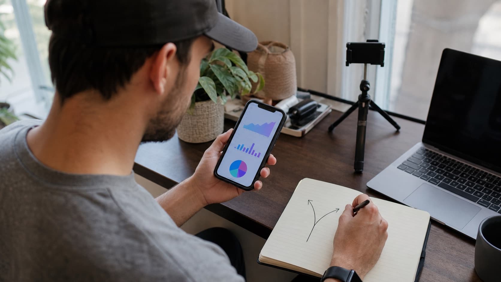 Creator comparing video analytics while sketching two paths for the next post